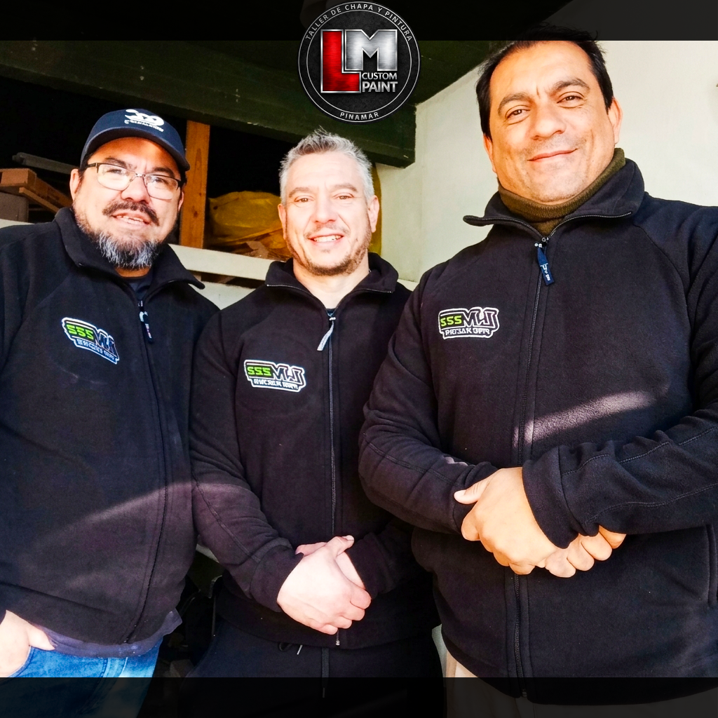 Tres personas en el taller de chapa y pintura.